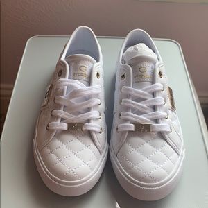 White with gold decal guess sneakers.